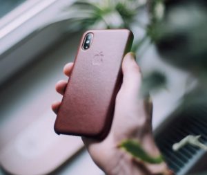 Man holds phone in leather case